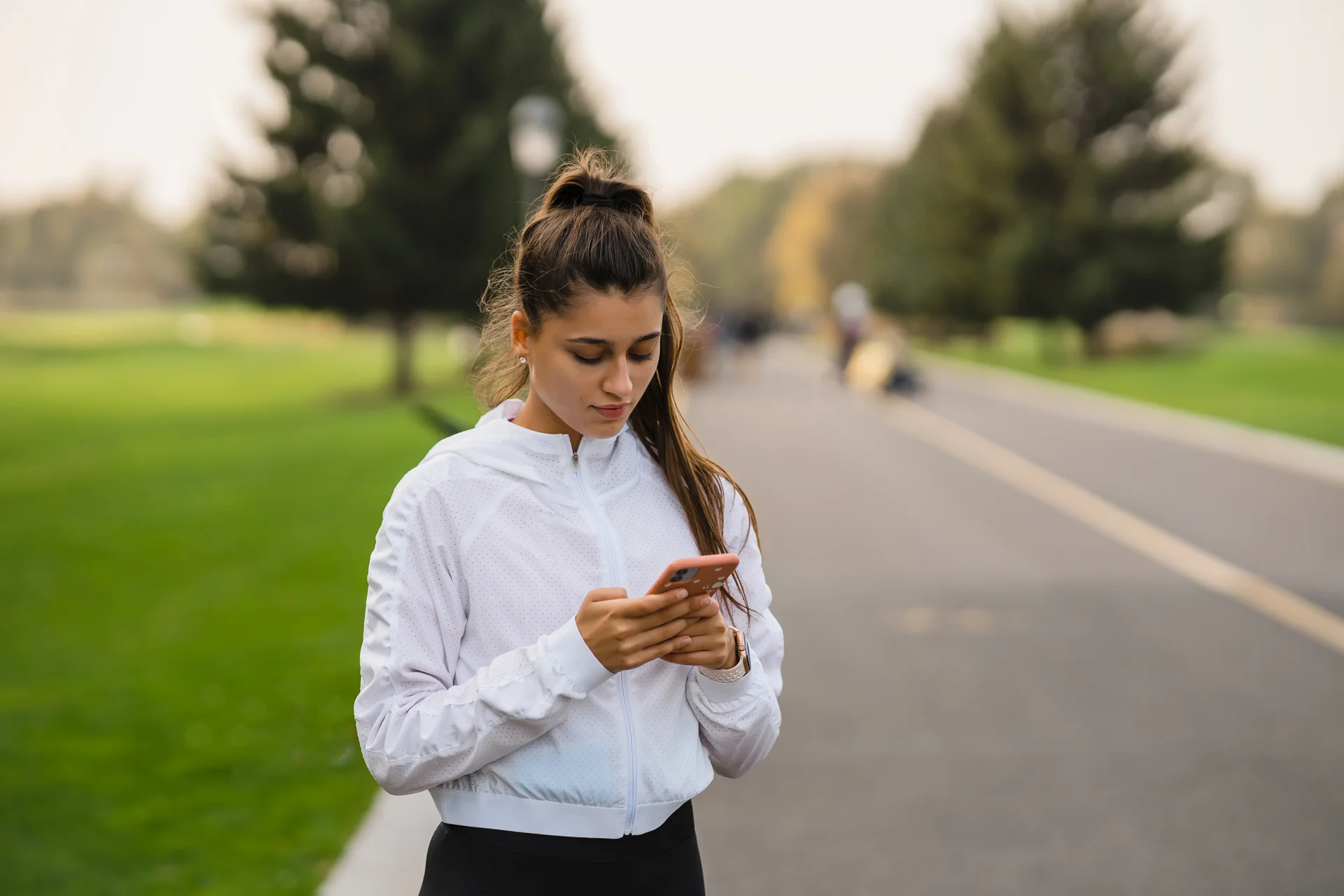 Young woman using smartphone after jogging